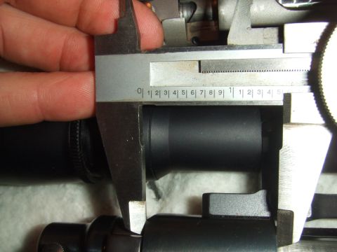 1996 Ford Bronco - A caliper is used to measure the diameter of a black cylindrical component, with visible inch markings on the tool.