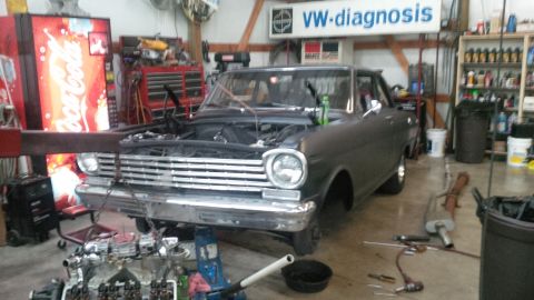 1963 Chevrolet Nova - Workshop scene with a 1963 Chevrolet Nova undergoing repairs, engine components visible.