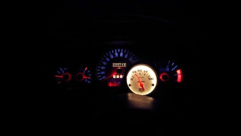 2000 Mercury Grand Marquis - Illuminated car dashboard gauges and odometer at night.