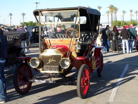 1990 Ford Bronco - This antique Ford Model T touring car is displayed at an outdoor event with other vehicles and people.