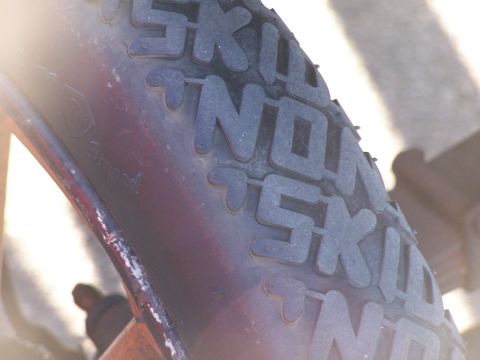 1990 Ford Bronco - The tire tread shows the words 'SKINNY' and 'NON' molded into the rubber.