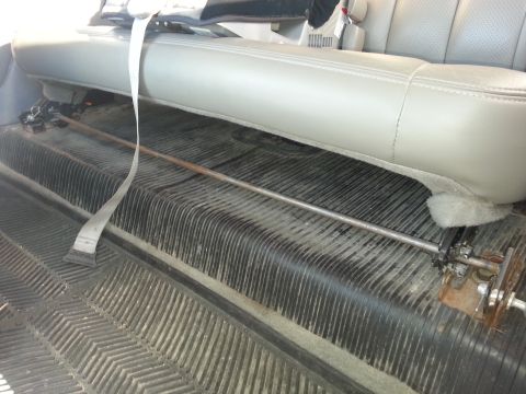 1995 Ford Bronco - Interior view of a vehicle showing gray leather seats and textured rubber floor mats.