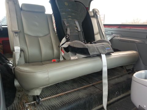 1995 Ford Bronco - The interior of a vehicle shows a child car seat secured in the back seat.