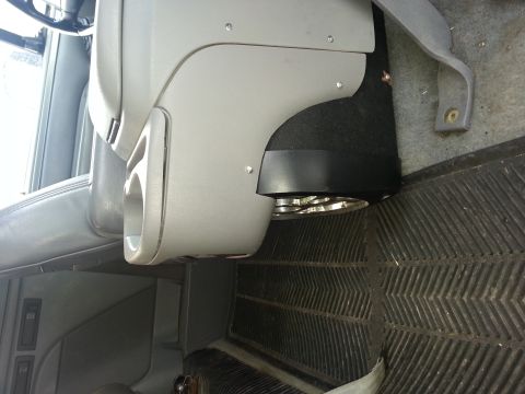 1995 Ford Bronco - Close-up of a vehicle's interior console and floor mat, with a speaker installed.