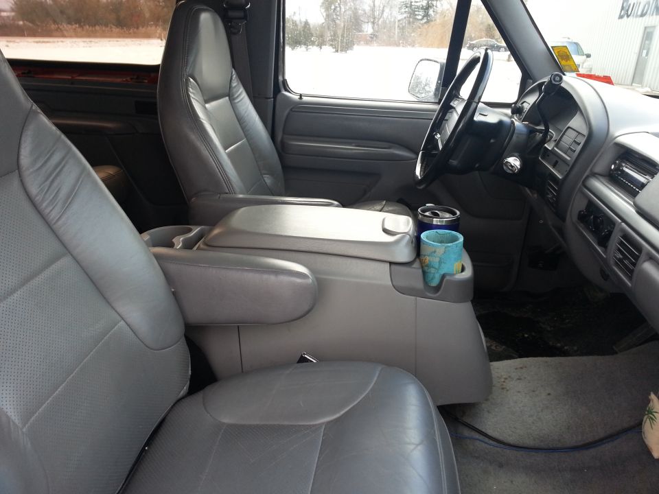 Gray leather interior of a truck with bucket seats and center console