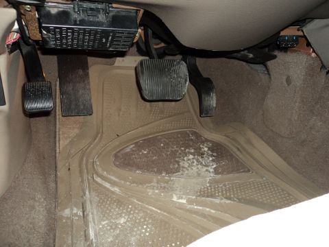 2004 Mercury Grand Marquis - Footwell view of pedals and fuse box in a vehicle interior.