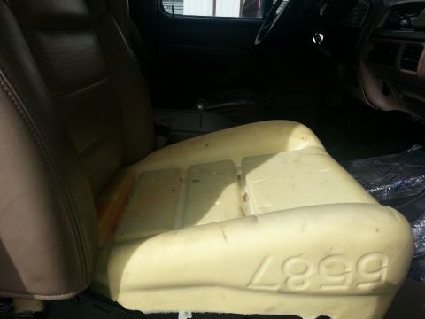1994 Ford Bronco - Removed seat cushion foam shows molded numbers "1999" and part of the vehicle's leather seat.