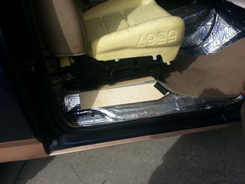 1994 Ford Bronco - Soundproofing is being installed inside the vehicle's interior, with a part number visible on the seat foam.