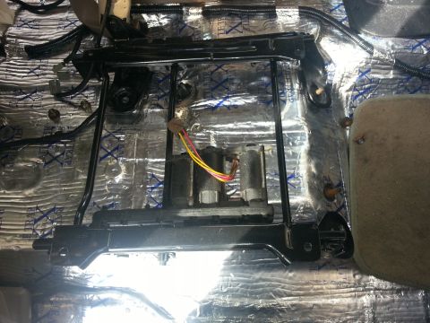 1994 Ford Bronco - A power seat mechanism with exposed wiring is visible, installed over sound-dampening material on the vehicle floor.