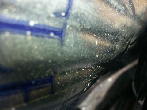 1994 Ford Bronco - A close-up view of a dusty interior car component, possibly a seat frame or trim piece.