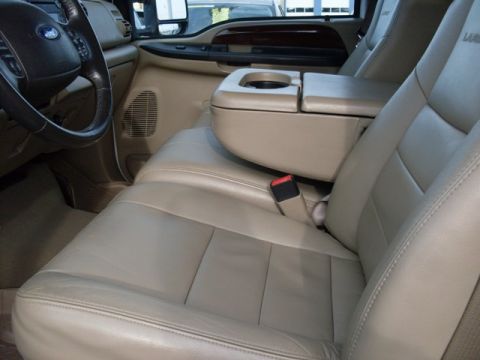 1995 Ford F-150 - The interior of a truck shows tan leather seats and a center console with a Ford steering wheel visible.