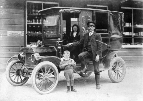 1912 Ford Model T - A family poses with their touring car in front of a store.