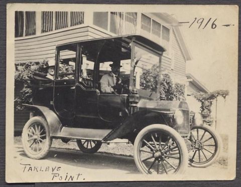 1914 Ford Model T - This 1916 Ford Model T Touring Car is seen with passengers in front of a building.