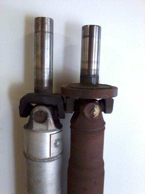 1999 Mercury Grand Marquis - Comparison of two driveshafts, one appearing newer and the other showing significant rust.