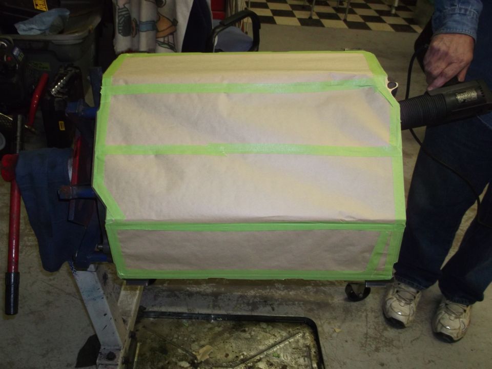 Engine block covered in brown paper and green tape, being worked on