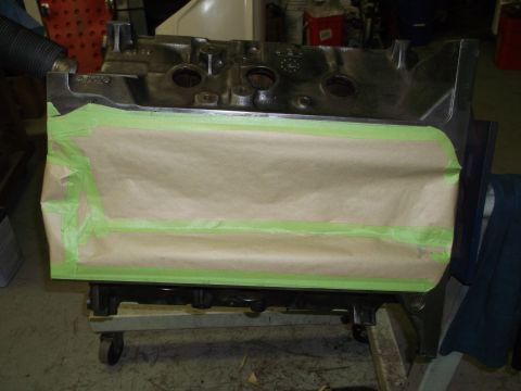 1967 Ford Mustang - An engine block is prepared for painting with masking paper and tape covering a section.