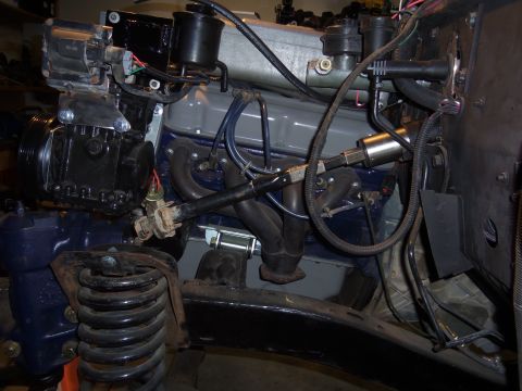 1968 Ford Bronco - Close-up view of the engine bay, highlighting the steering upgrade components and exhaust system.