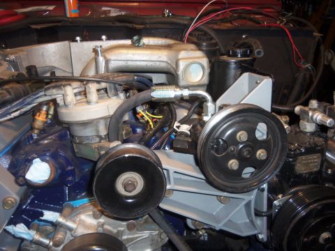 1968 Ford Bronco - Close-up view of the engine bay, focusing on the power steering pump and associated pulleys and hoses.