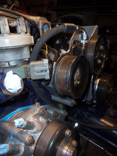 1968 Ford Bronco - Engine components including pulleys, hoses, and a distributor cap are visible in this close-up shot.