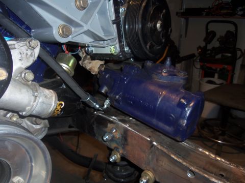 1968 Ford Bronco - Close-up view of a blue steering gear box installed on a vehicle frame, with engine parts in the background.