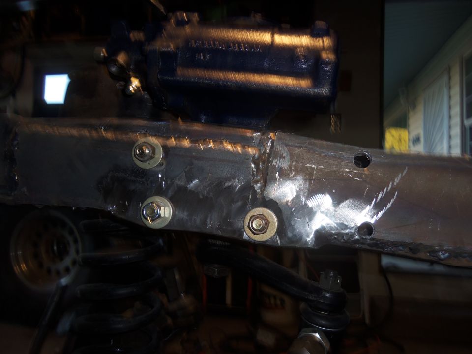 Steering box mounted to modified frame with new bolts. Suspension components visible below