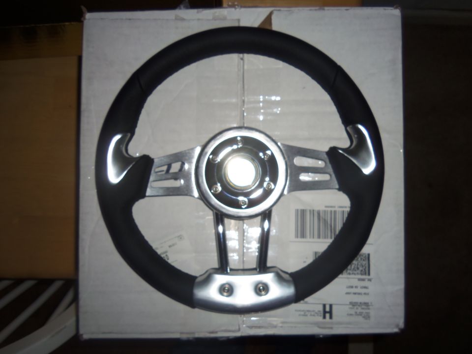 Aftermarket steering wheel with black grip and chrome spokes