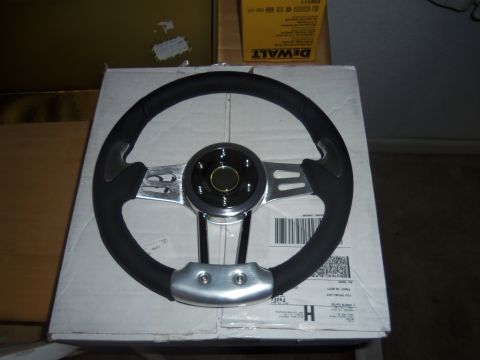 1968 Ford Bronco - Aftermarket steering wheel with black grip and chrome spokes is shown on a box.