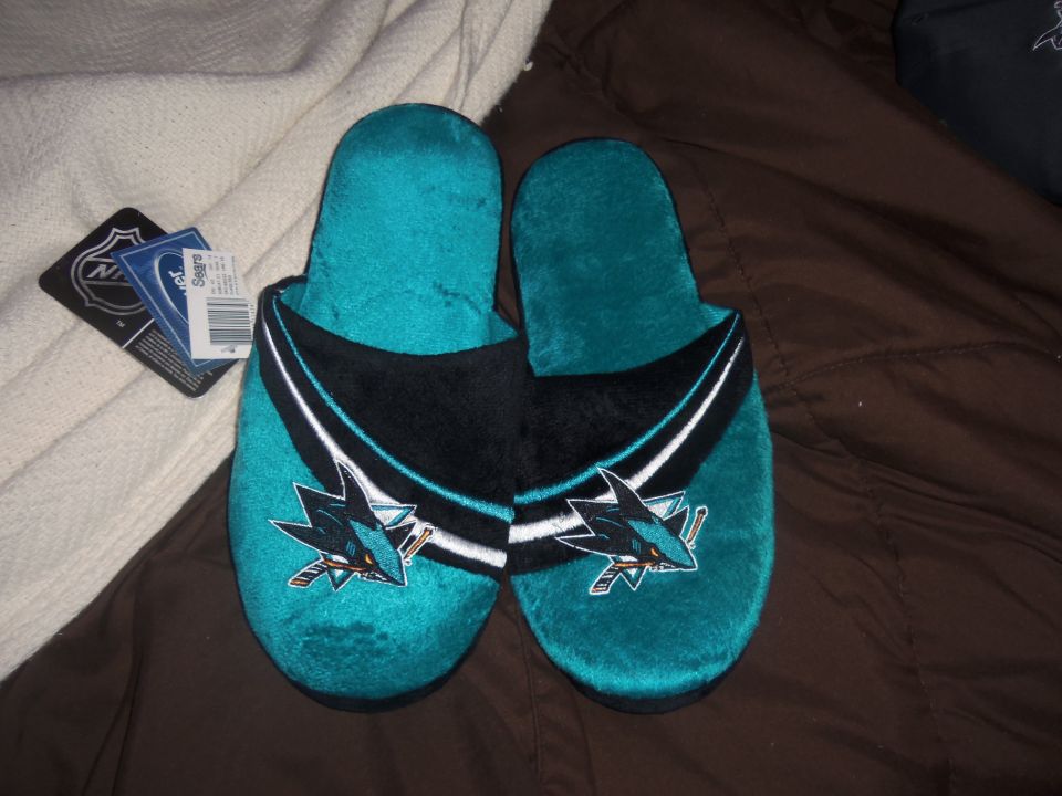 Pair of teal San Jose Sharks logo slippers with tags attached