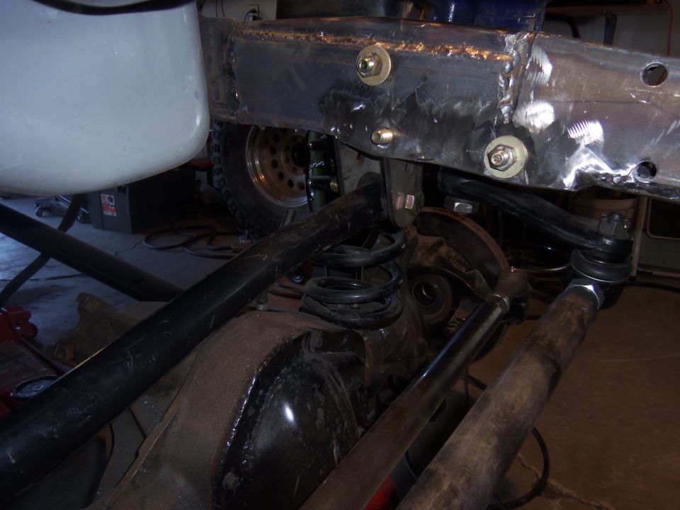 Close-up of a Ford Bronco's rear axle, suspension springs, and frame modifications