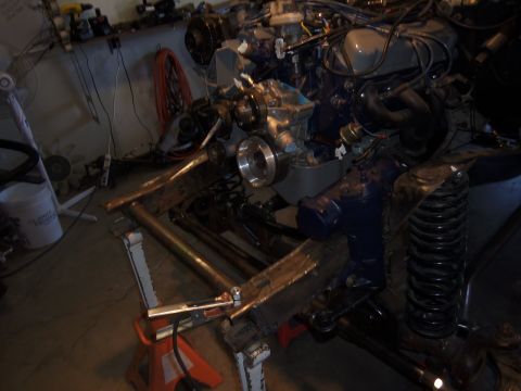 1968 Ford Bronco - Engine and suspension components are visible, supported by jack stands in a workshop setting. The Supermotors logo is present in the lower…