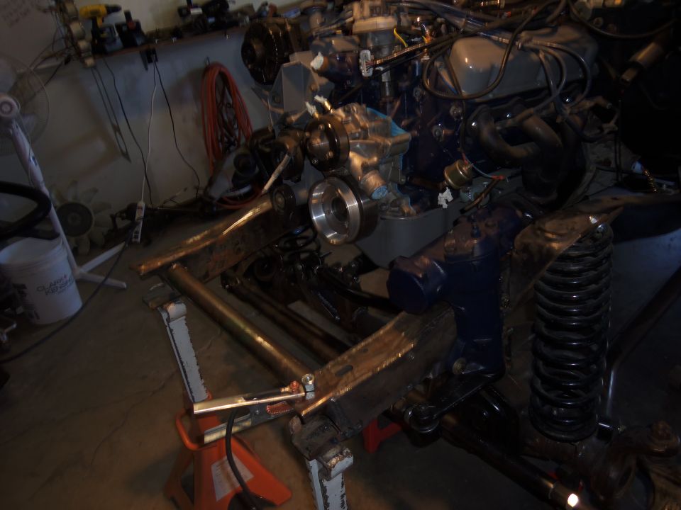 Engine and suspension parts on jack stands, Supermotors logo visible