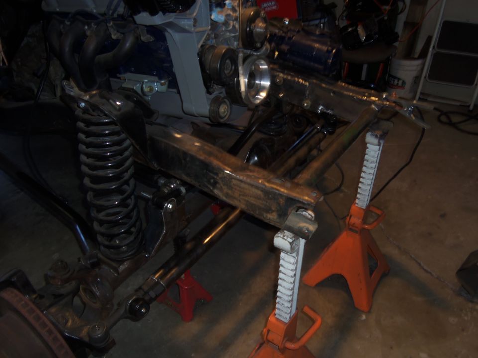 vehicle frame with engine parts and suspension components on jack stands