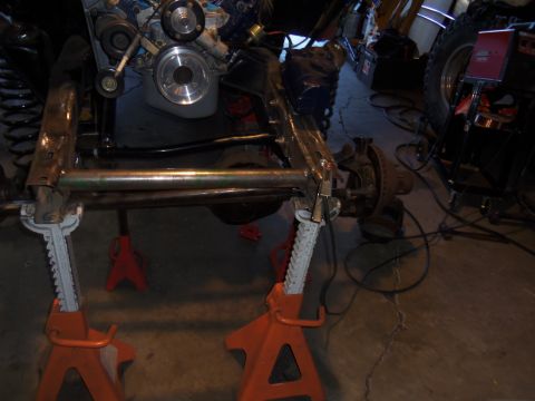 1968 Ford Bronco - Close-up view of vehicle undercarriage and engine components, supported by jack stands.