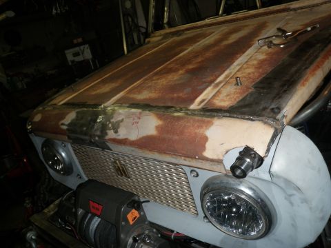 1961 International Scout 800 - Front view of a 1961 International Scout 800 undergoing bodywork, a rusty hood and new grille.