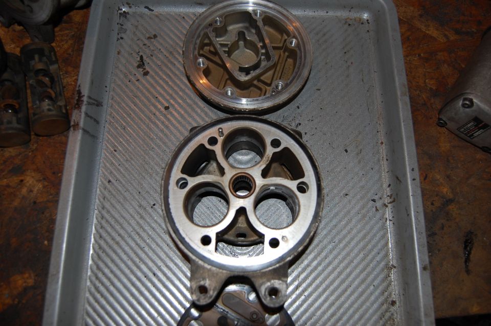 Disassembled Honda Rancher engine crankcase parts and cover laid on a metal tray on a workbench