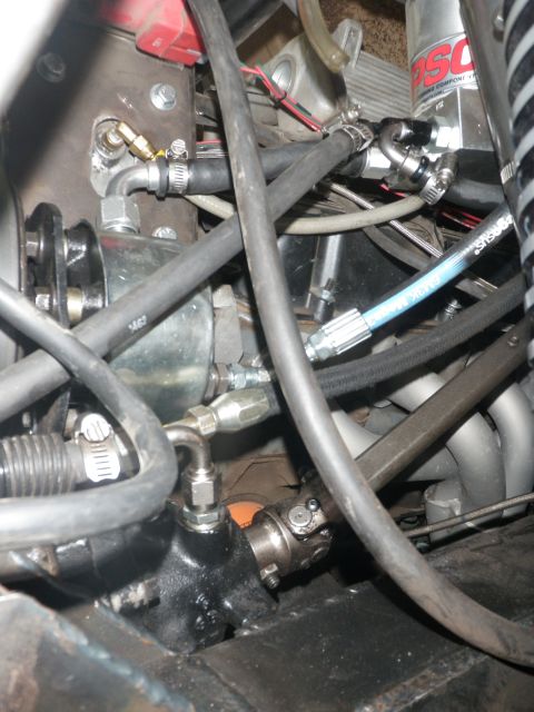 1961 International Scout 800 - This close-up shows various engine bay components, including hoses, fluid lines, and part of the steering system.