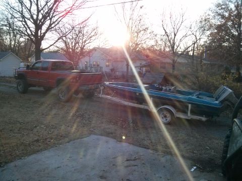 1986 Ford Bronco - A red pickup truck is hitched to a trailer carrying a boat.