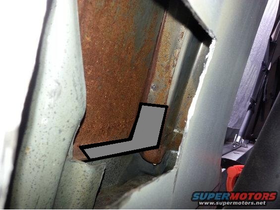 rusted metal frame with a gray L-shaped marking, likely a vehicle chassis part