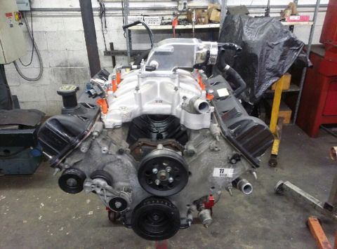 2004 Ford Crown Victoria - Engine assembly with a prominent supercharger and intake manifold, likely undergoing modifications or rebuild.