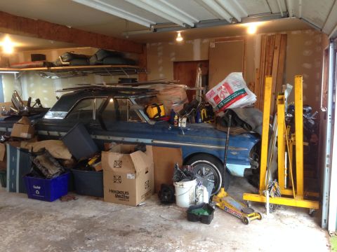 1964 Ford Fairlane - A blue station wagon is surrounded by storage bins, boxes, and automotive equipment in a garage.