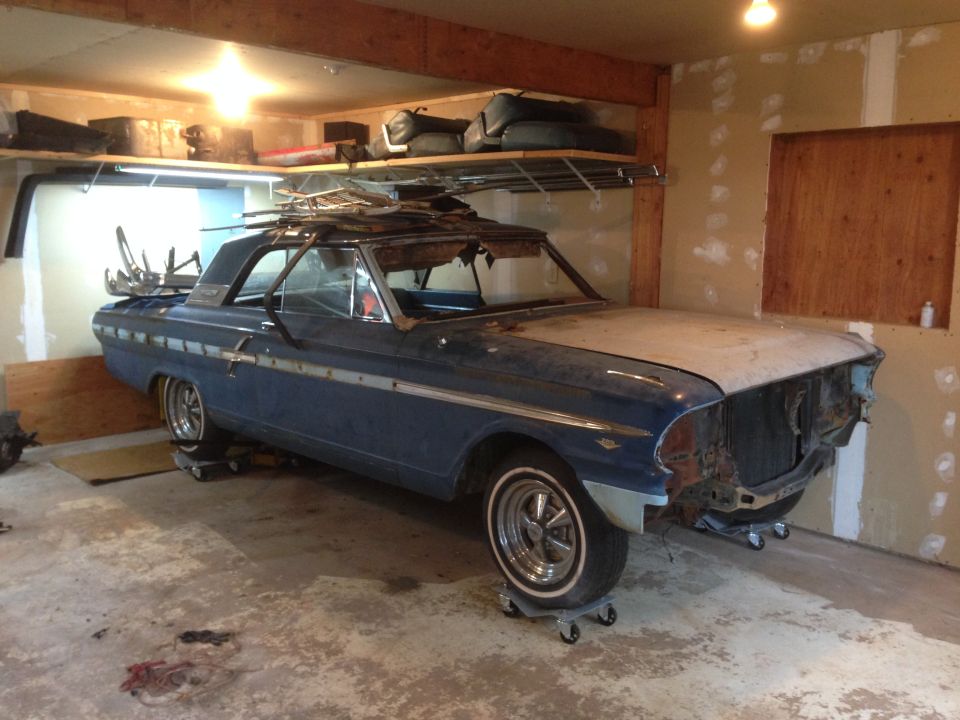 Blue 1964 Ford Fairlane in garage, missing front grille and hood