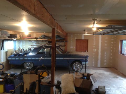 1964 Ford Fairlane - A blue coupe is parked inside a garage, surrounded by storage and construction materials.