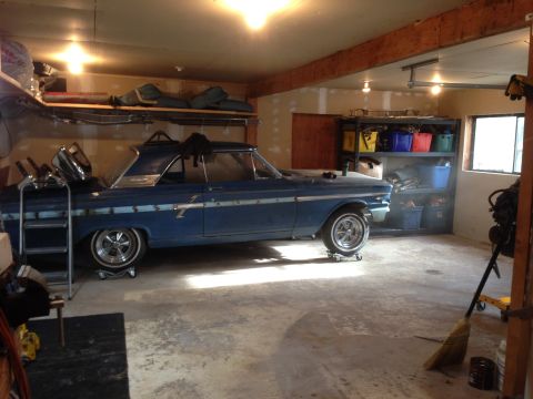 1964 Ford Fairlane - A blue 1964 Ford Fairlane coupe is parked inside a garage, resting on dollies.