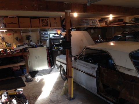 1964 Ford Fairlane - A 1964 Ford Fairlane is parked in a cluttered garage with its hood and door open.