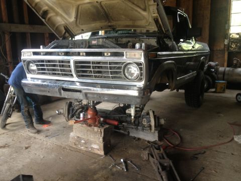 1970 Ford F-250 - Front end of a Ford truck undergoing repairs, with the suspension components removed and the vehicle elevated.