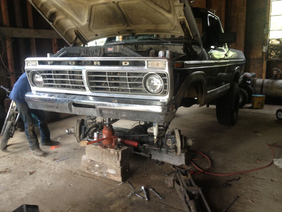 Ford truck front end lifted on blocks with suspension removed for repair. The grille has 'FORD' lettering
