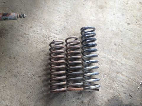 1970 Ford F-250 - Three coil springs and a shock absorber are shown on a concrete floor.