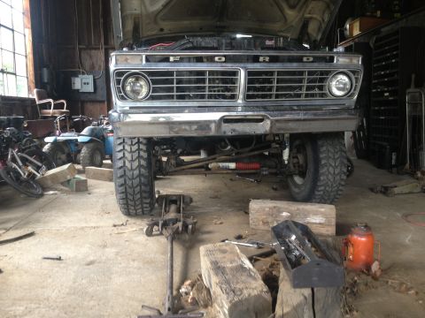 1970 Ford F-250 - This 1973 Ford F-Series truck is in a garage with its hood up, showing the front grille and suspension components, likely for maintenance o…