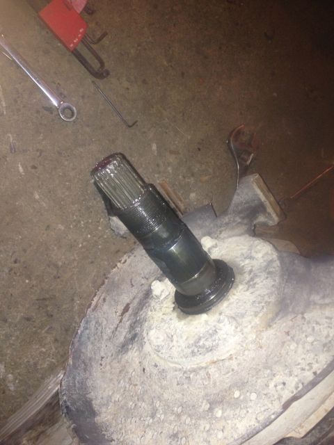 1970 Ford F-250 - Close-up of a splined shaft emerging from a differential housing, with tools on the ground.