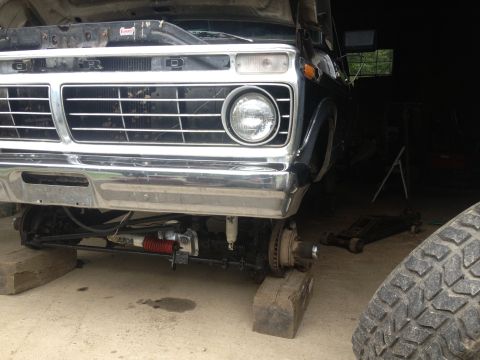 1970 Ford F-250 - Front view of a black Ford truck undergoing maintenance, showing its grille and suspension components.